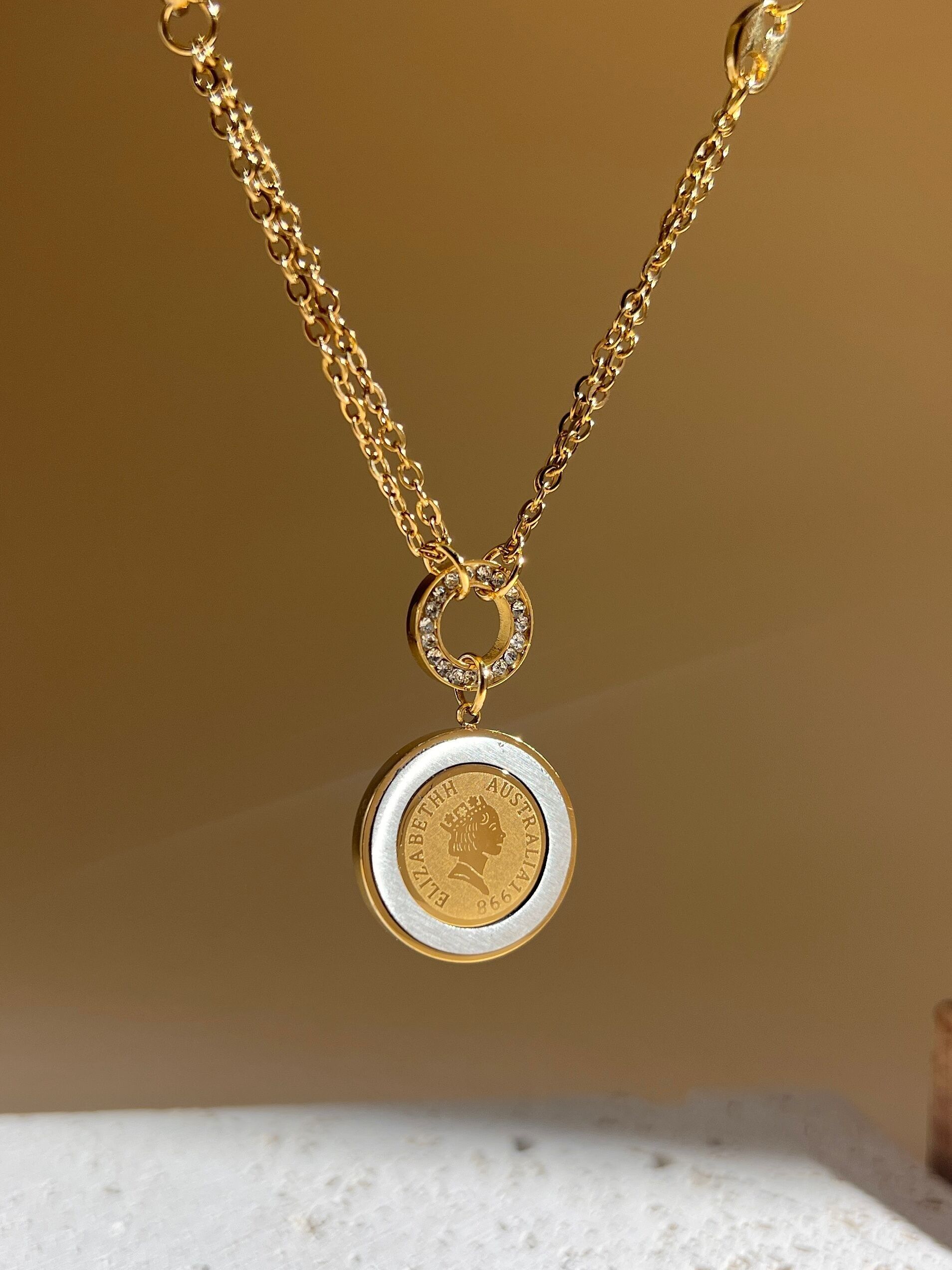 Collar de cadena fina con colgante redondo de nácar y diamantes de imitación en acero.