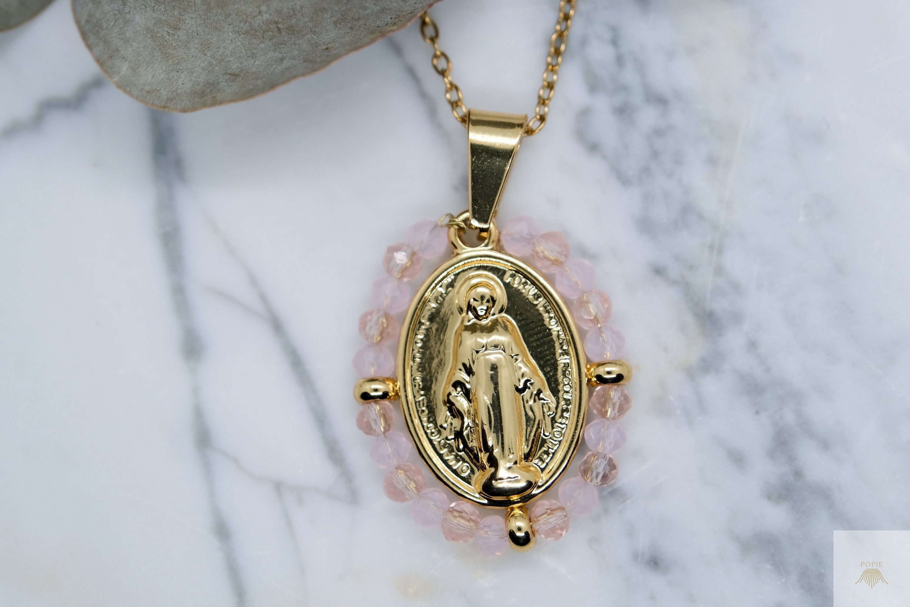 Our Lady Large Model Necklace surrounded by opaque and transparent pale pink pearls