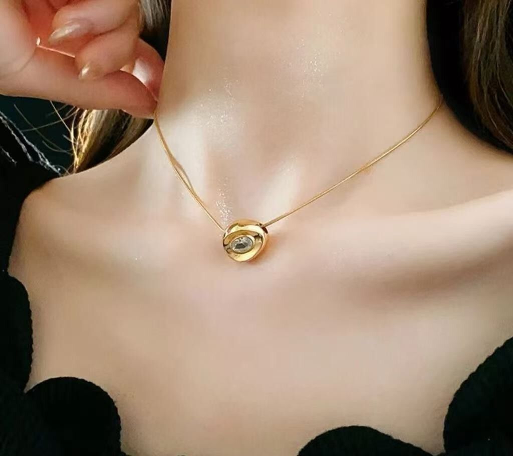 Collar de acero inoxidable bañado en oro con colgante de cristal.