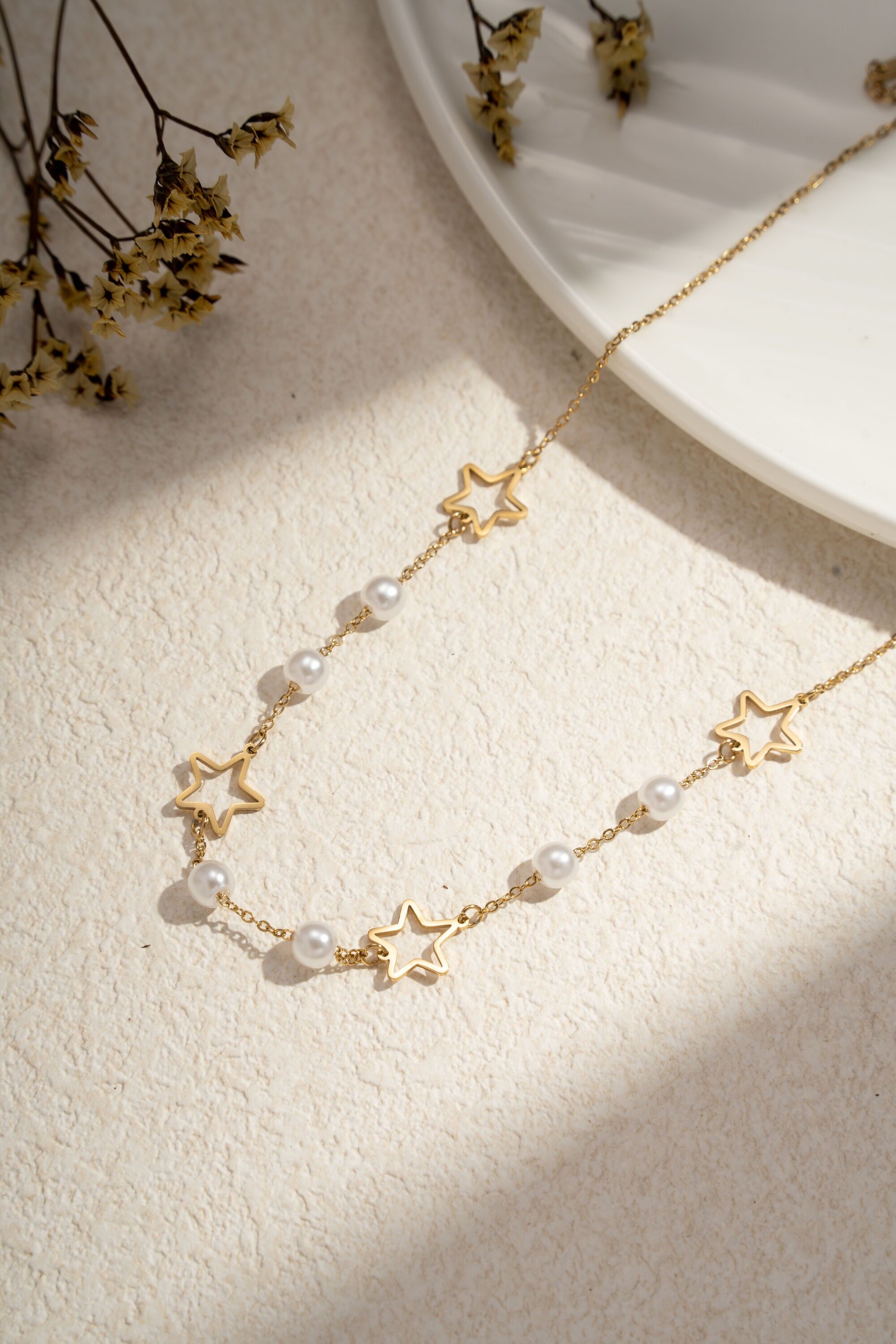 Collar de acero inoxidable con estampado de estrellas y perlas doradas