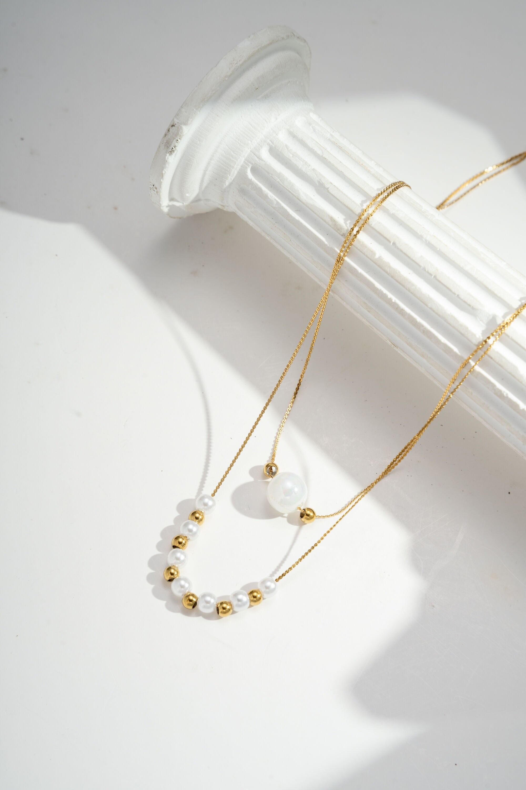 Collar de doble vuelta con elegantes perlas en acero bañado en oro.