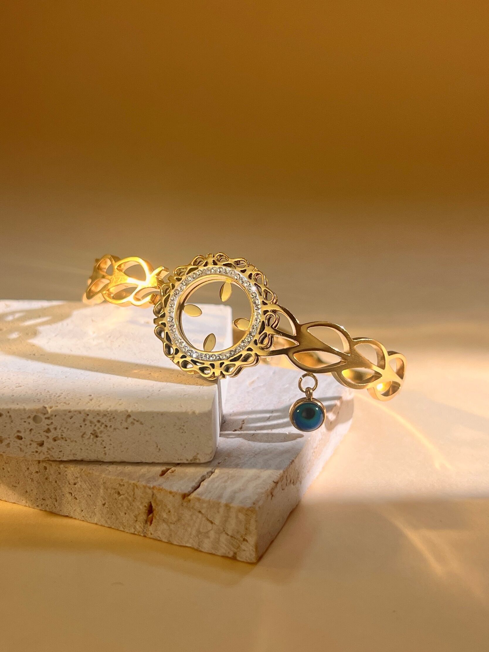 Pulsera de acero inoxidable con diamantes de imitación redondos y dije de ojo.