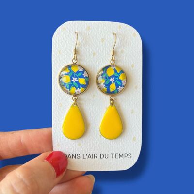 Lemon dangling earrings on a blue background, yellow enamel