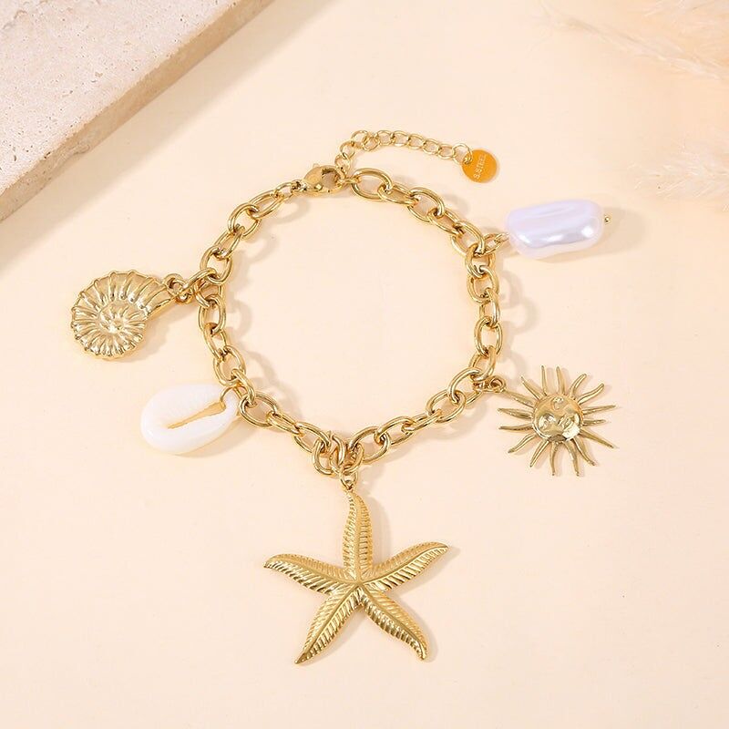Bracciale in oro con ciondoli a forma di stelle marine, conchiglie e perle
