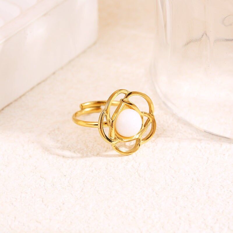 Anello a forma di fiore in oro con pietra interna bianca rotonda