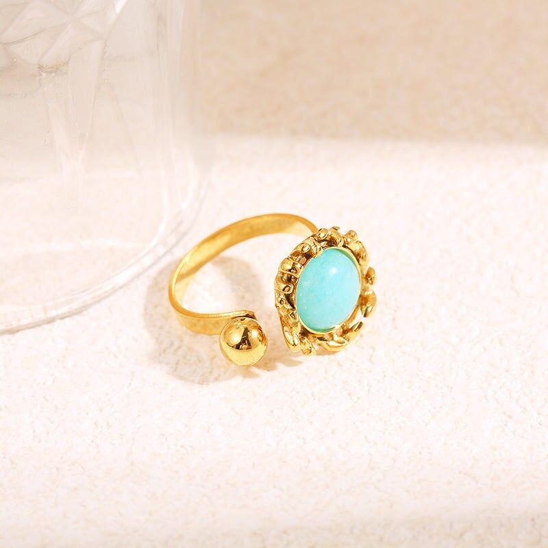 Anello in oro con apertura davanti alla sfera con pietra blu