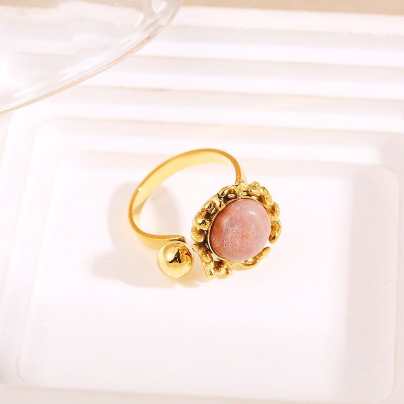 Anello in oro con apertura davanti a sfera con pietra rosa