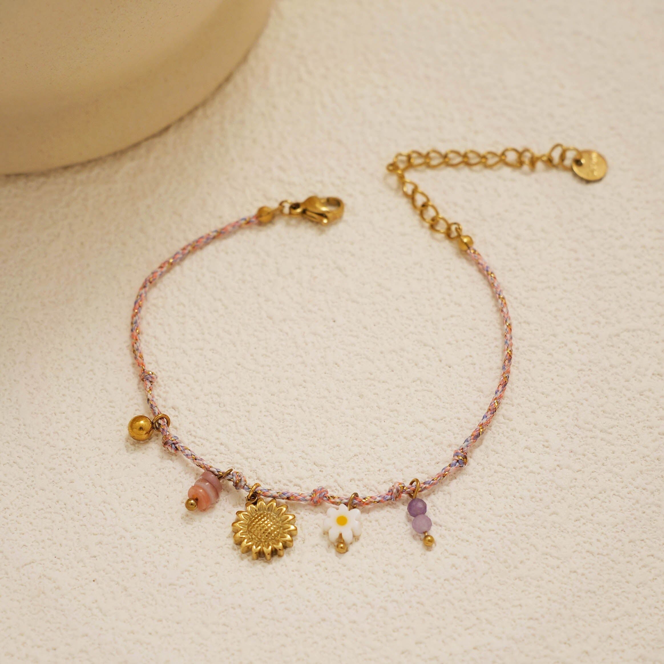 Bracciale in cordino lilla con ciondoli a forma di fiore