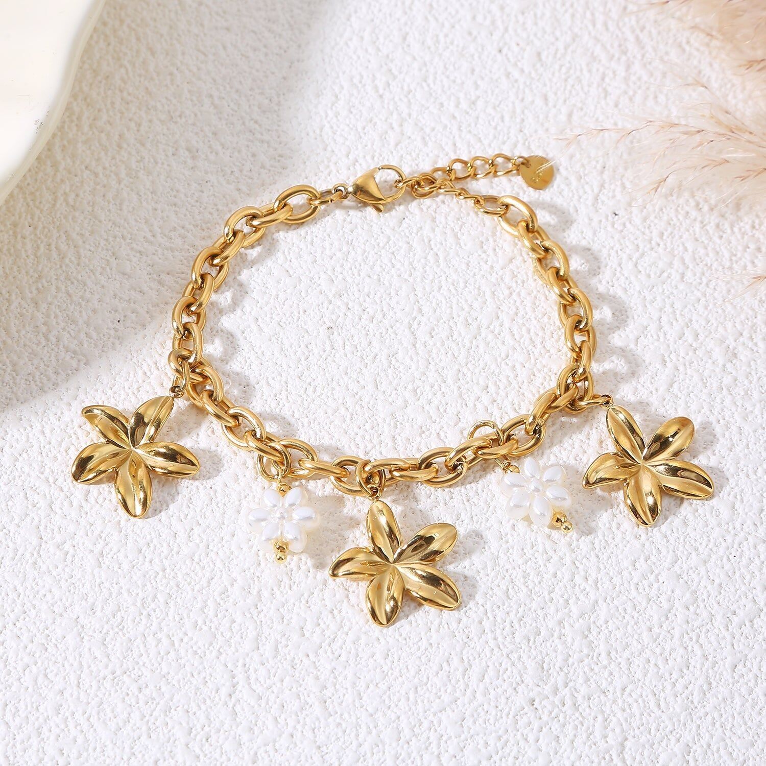 Bracciale a catena in oro con ciondoli a forma di fiore e perla