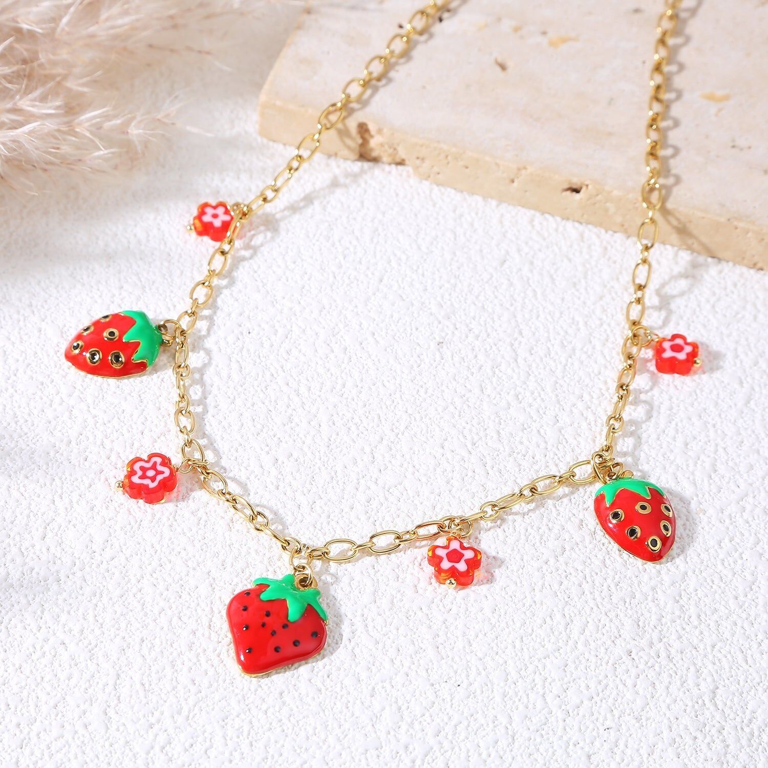 Collana con catena in oro con ciondoli a forma di fragola e fiore