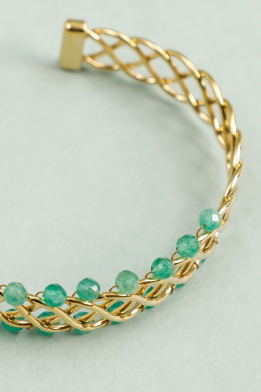 Bracciale rigido intrecciato in oro con perline verdi
