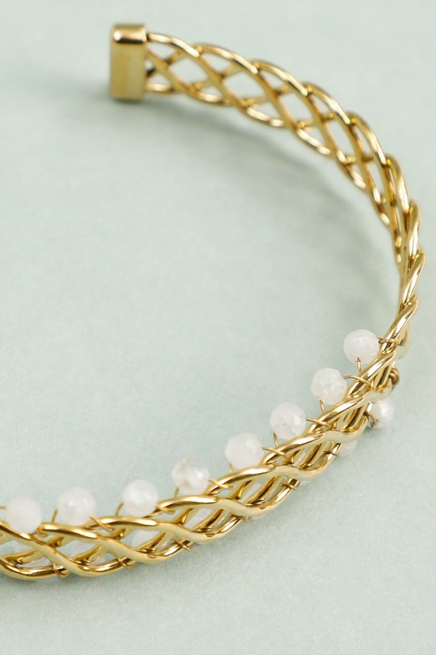 Bracciale rigido intrecciato in oro con perle bianche