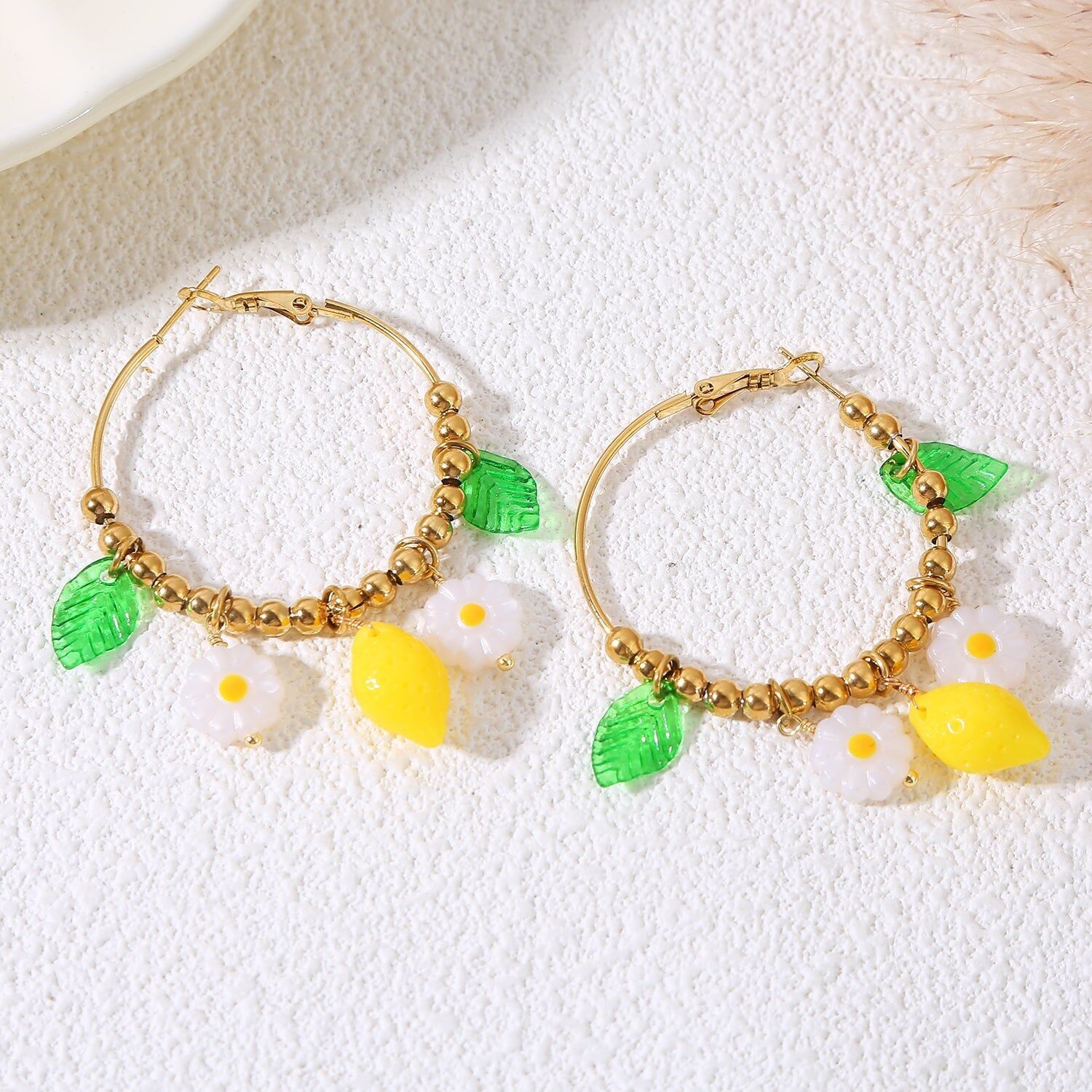 Orecchini a cerchio placcati in oro con limone e margherita