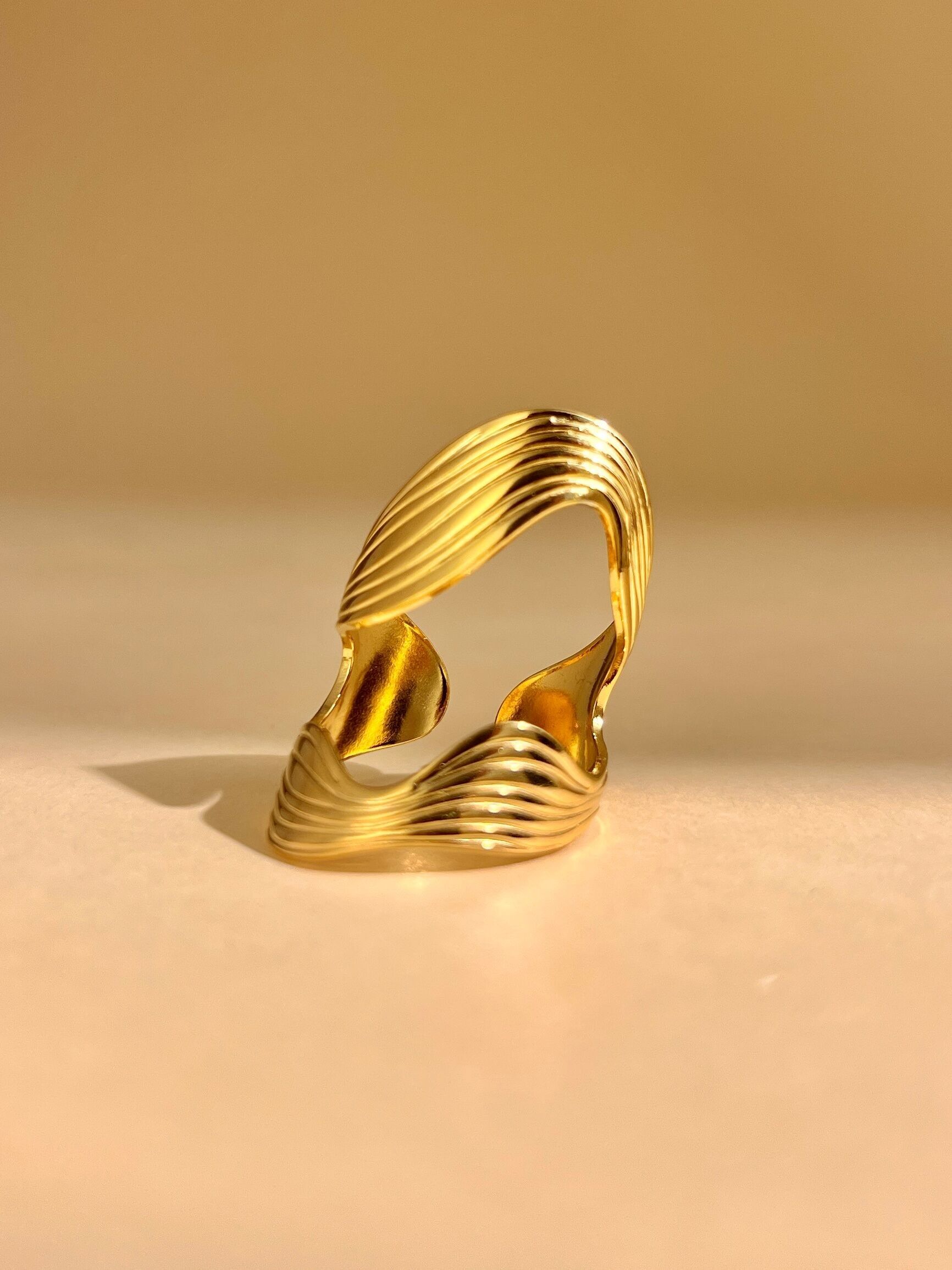Adjustable gold stainless steel ring with modern wave design
