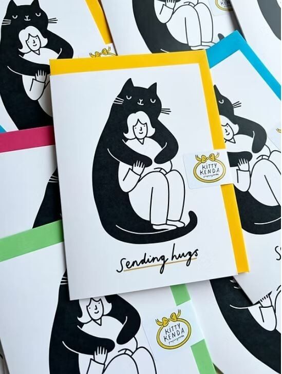 Biglietto d'auguri con gatto gigante che invia abbracci