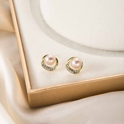 Pendientes de perla ruborizada iluminada por la luna con halo de cristal