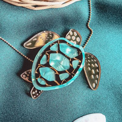 Elegante collana a forma di tartaruga tagliata al laser in vetro acrilico specchiato turchese, nero e oro su una catena color oro.