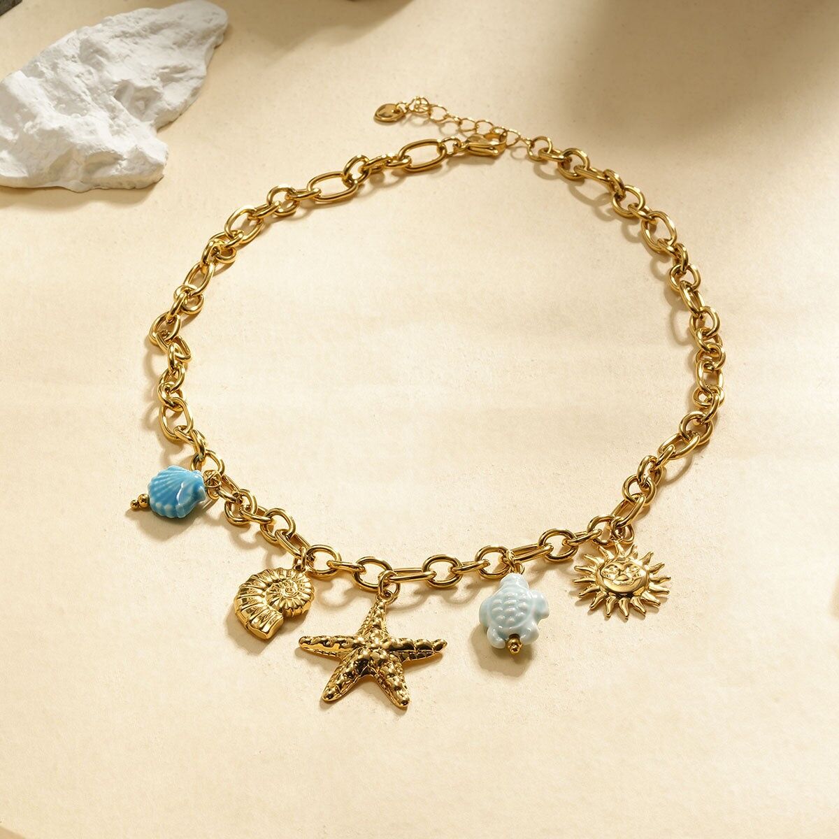 Collana con catena in oro con ciondoli a forma di stella marina, conchiglia e tartaruga blu