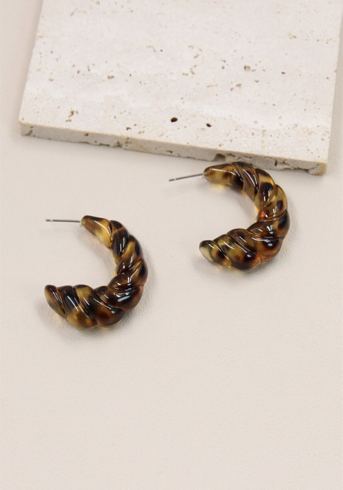 Geflochtene Creolen mit Leopardenmuster: Ein modisches Meisterwerk