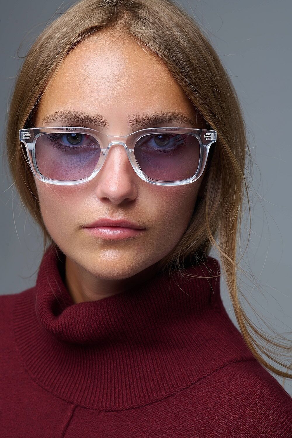 Klare, quadratische Sonnenbrille mit blauen Verlaufsgläsern und seitlichen Metalldetails