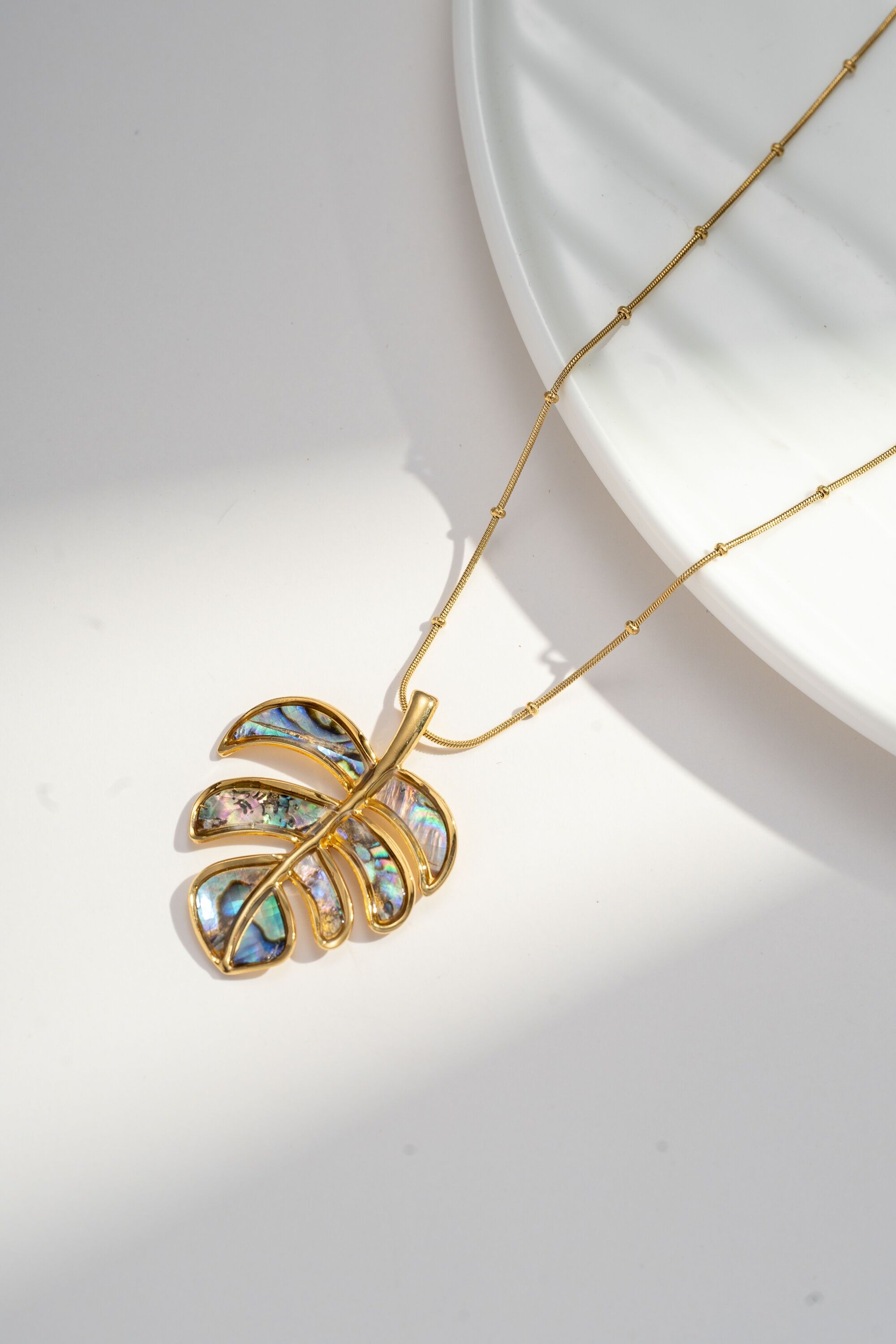 Iridescent mother-of-pearl tropical leaf necklace in gold-plated stainless steel