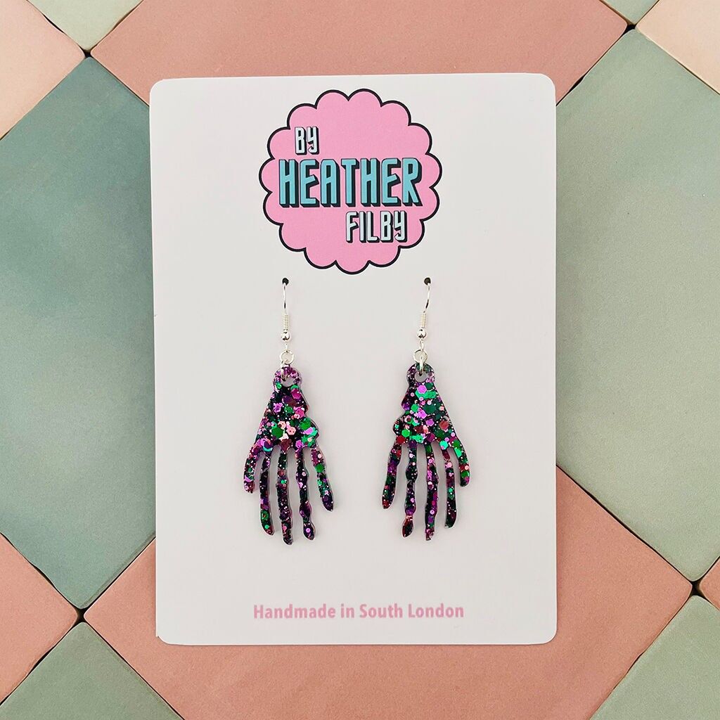 Orecchini in resina glitterata a forma di mano scheletrica