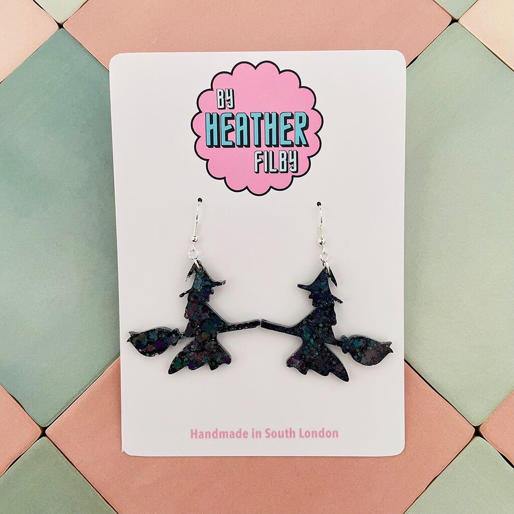 Orecchini di Halloween in resina glitterata con strega su una scopa