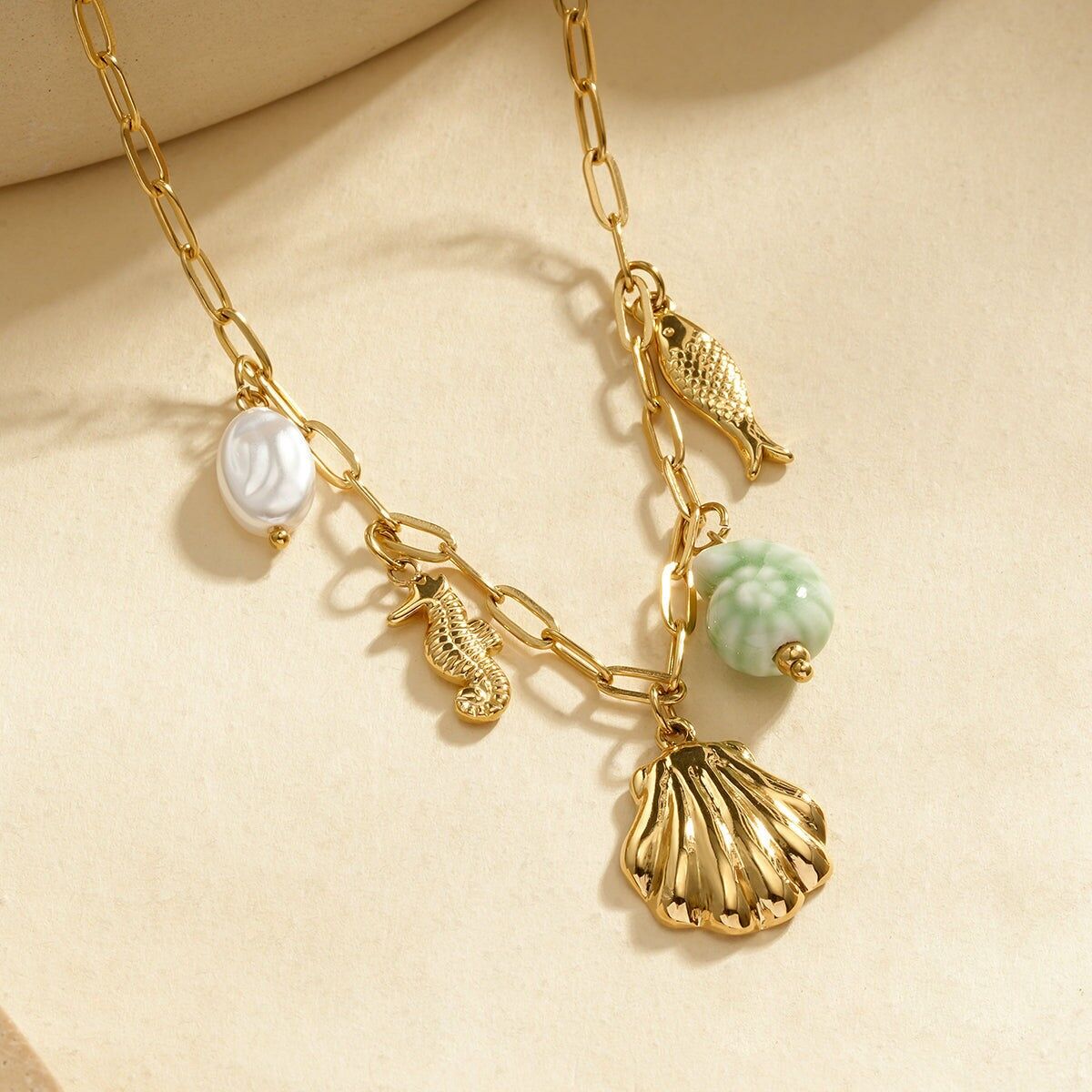 Collana con catena in oro e ciondoli con elementi marini