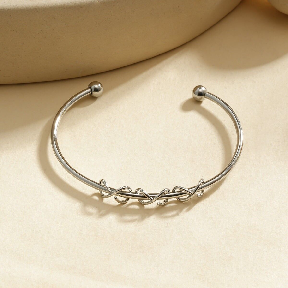 Bracciale rigido regolabile in argento con motivo a nodi intrecciati