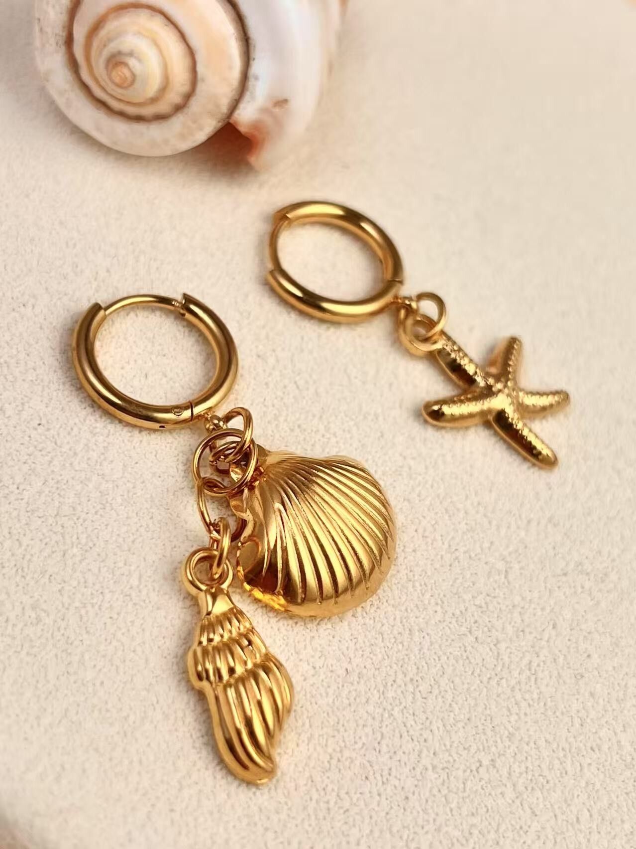 Asymmetrische Creolen aus Edelstahl mit Muschelanhängern