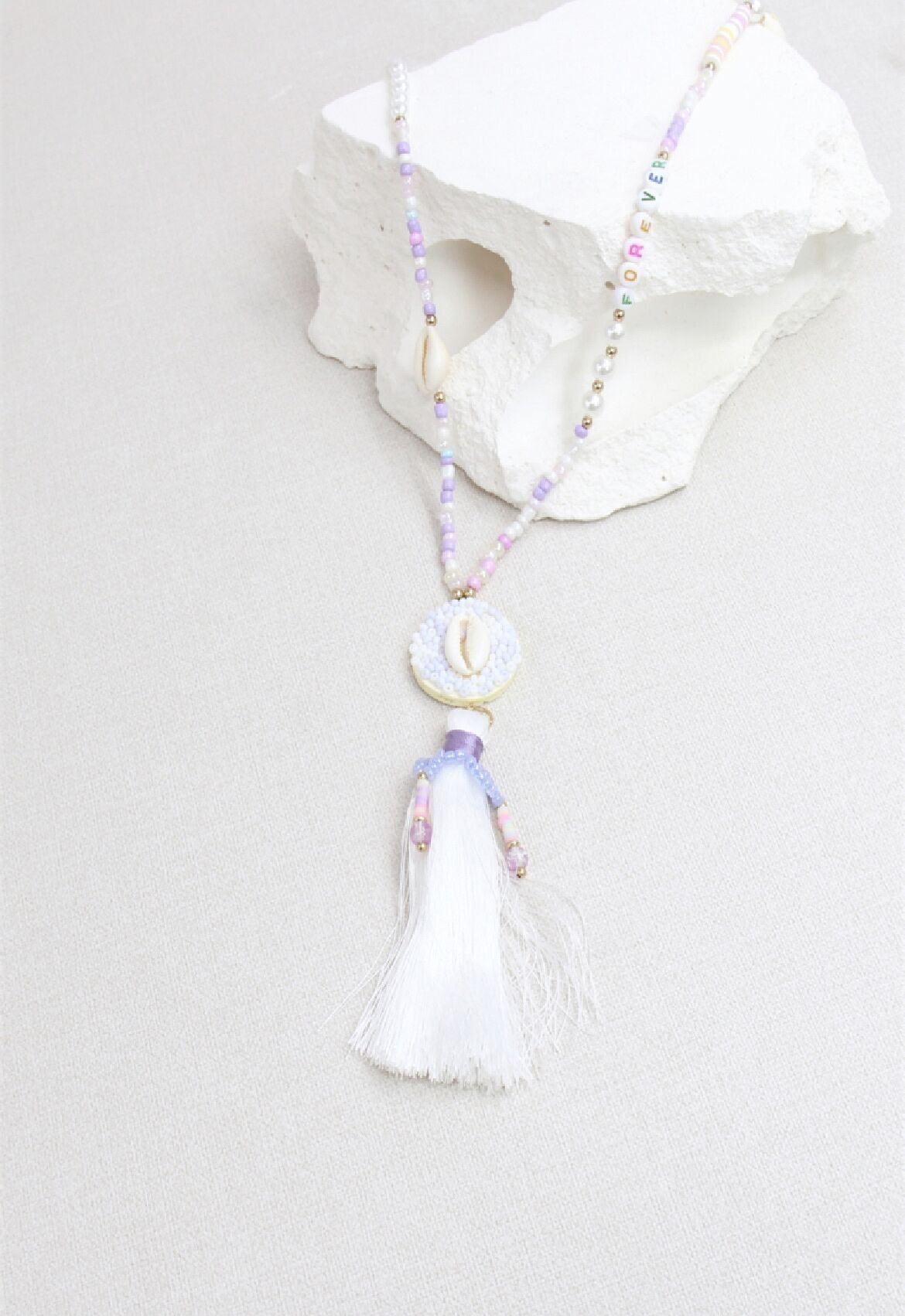 Halskette aus Kauri-Pompons mit Rocailles-Perlen