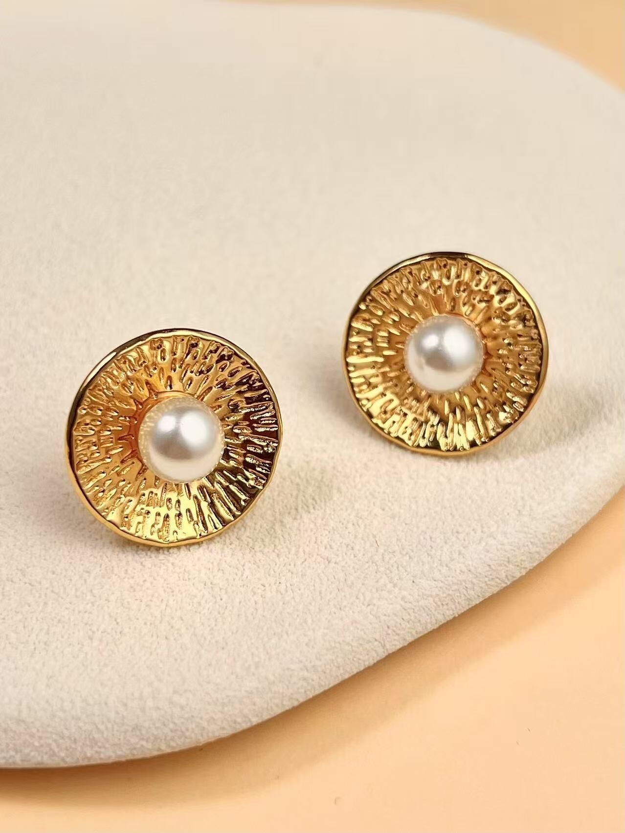 Orecchini in oro testurizzato con elegante perla centrale