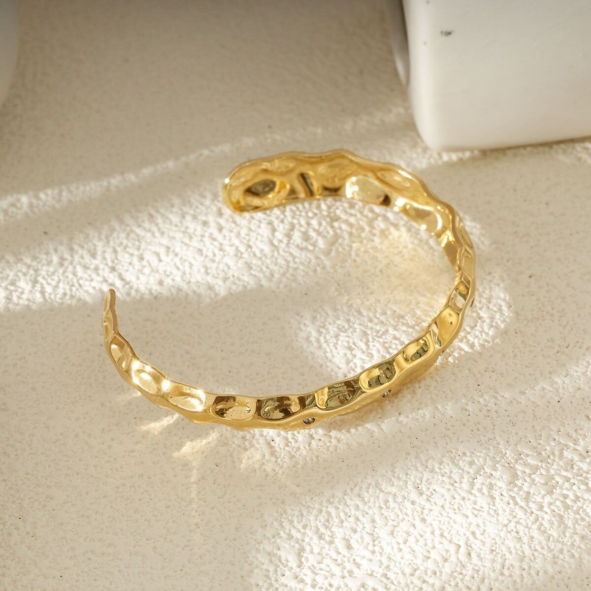 Bracciale rigido con effetto martellato testurizzato in oro con dettagli scolpiti