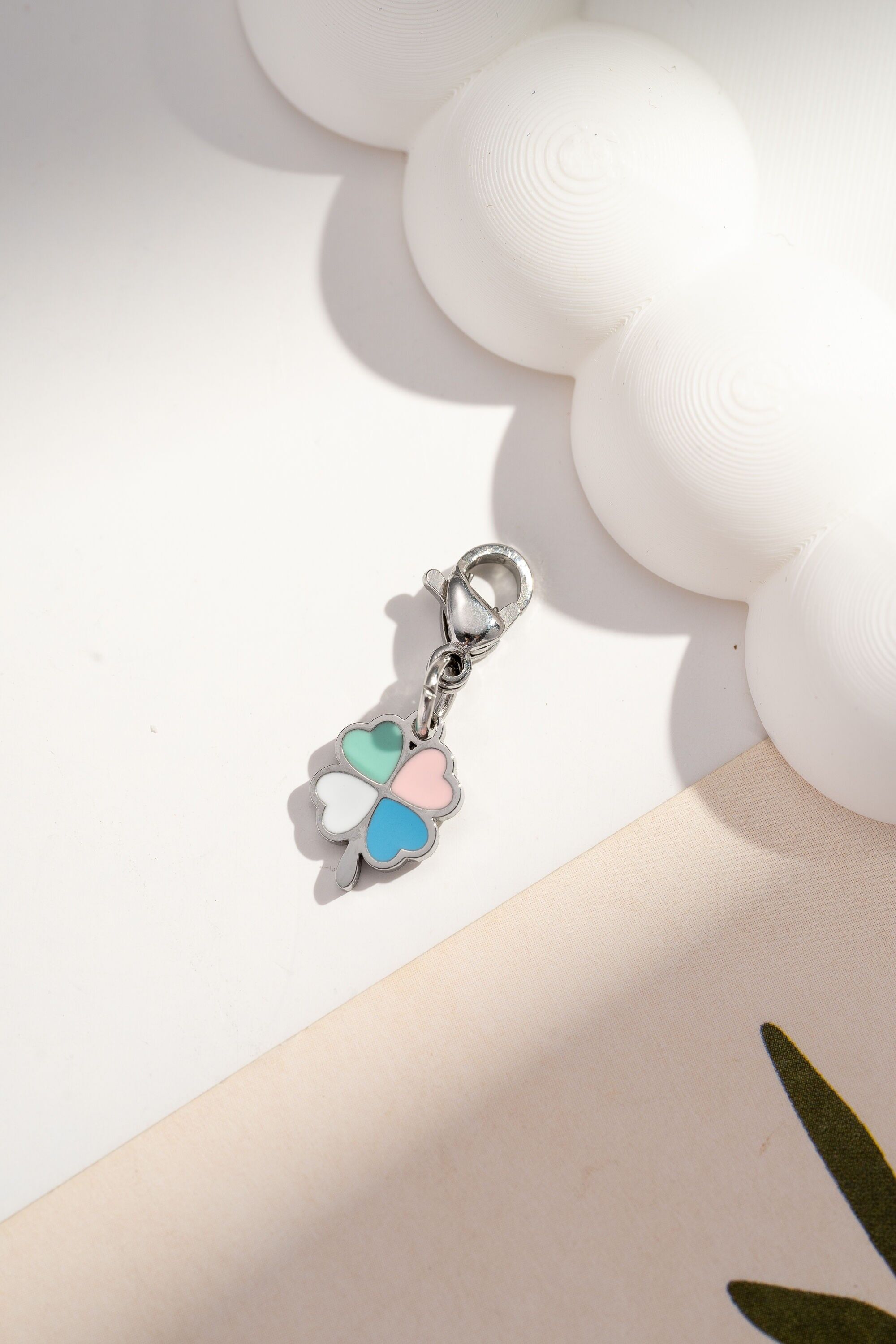 Ciondolo a forma di quadrifoglio con cuori smaltati color pastello