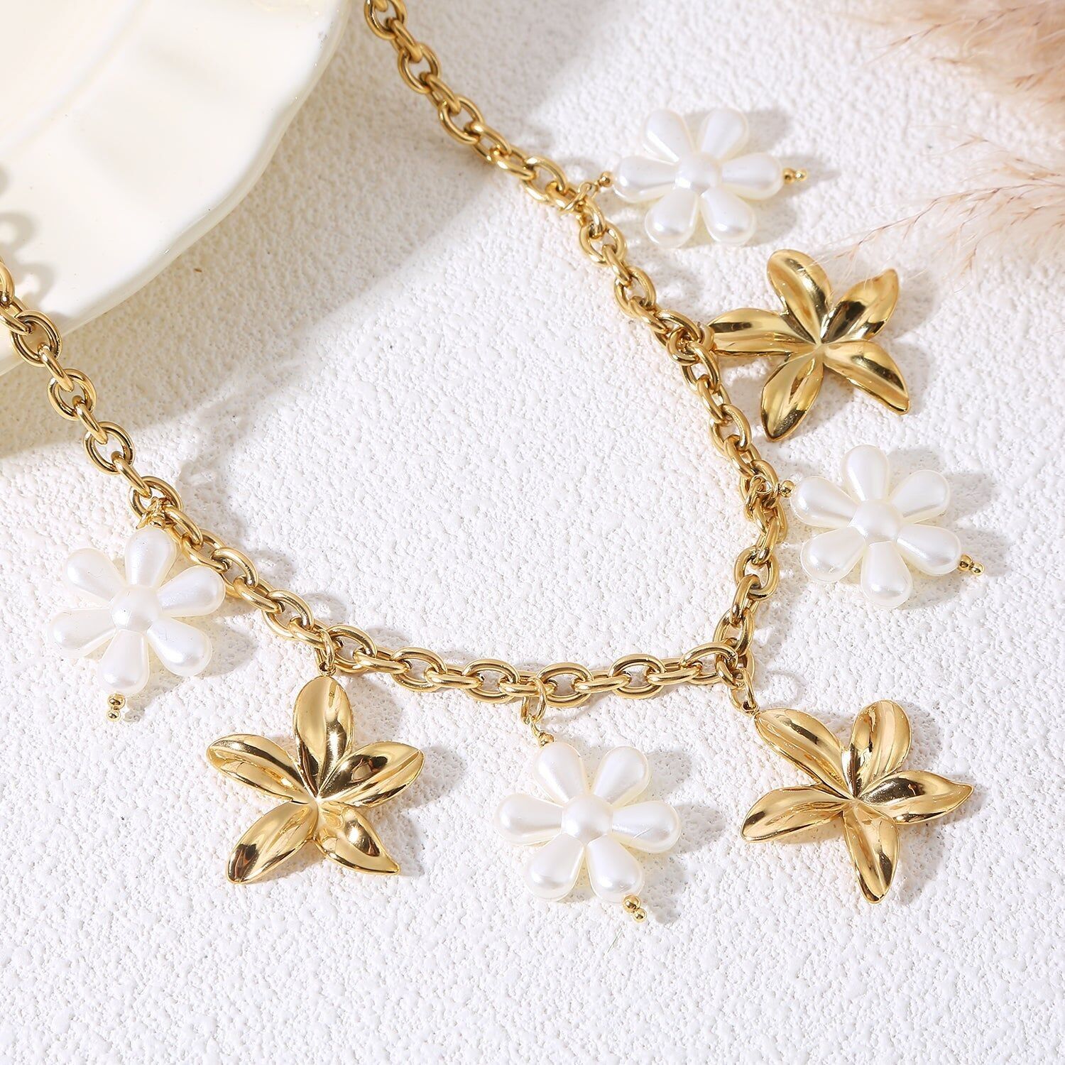 Collana a catena in oro con ciondoli a forma di fiore e fiori di perle