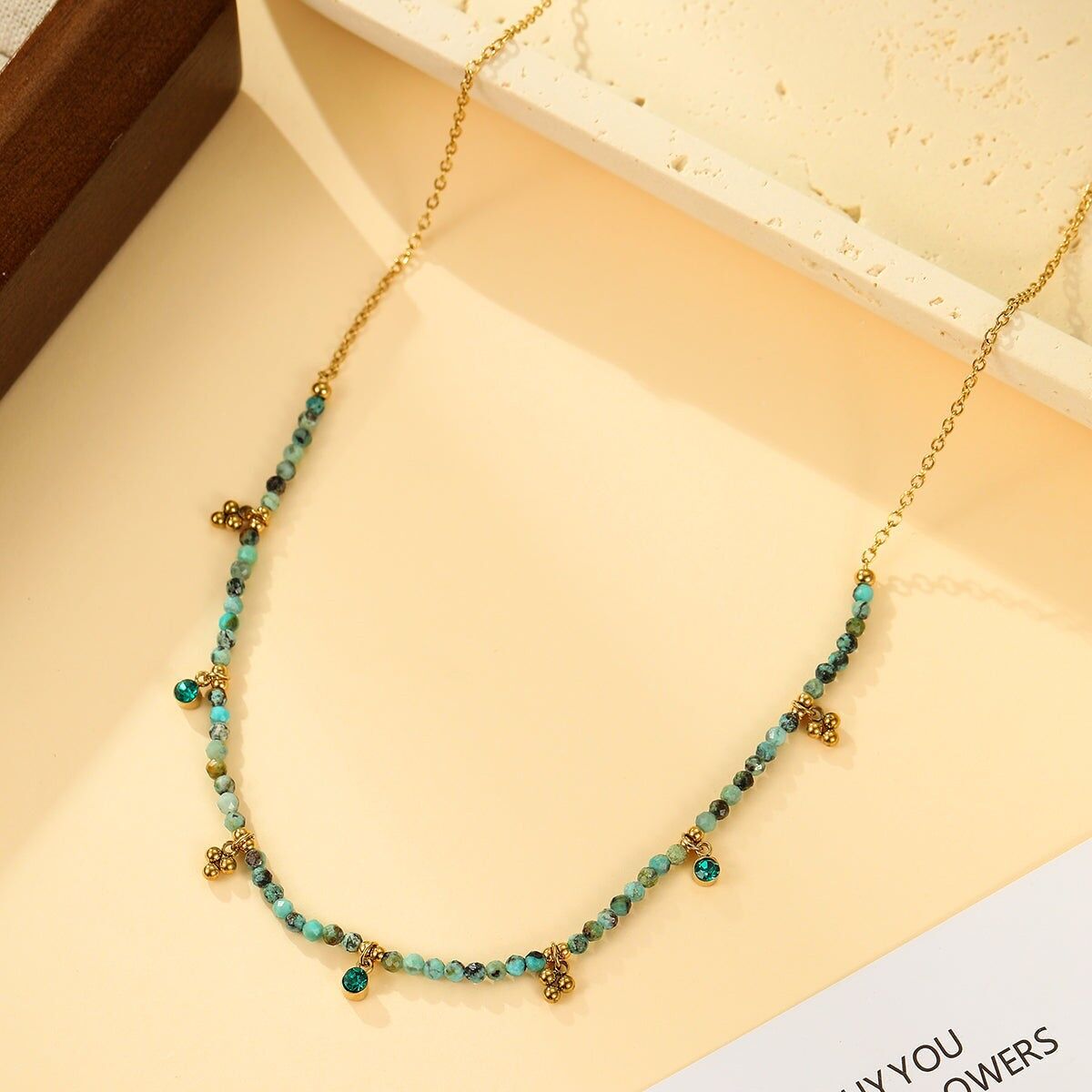 Collana in oro con perle sfaccettate, turchese africano verde e pendenti a forma di trifoglio