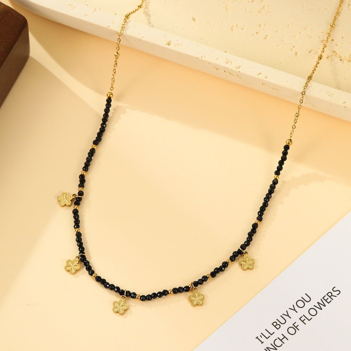 Collana in oro con perle sfaccettate nere e pendenti a forma di fiore