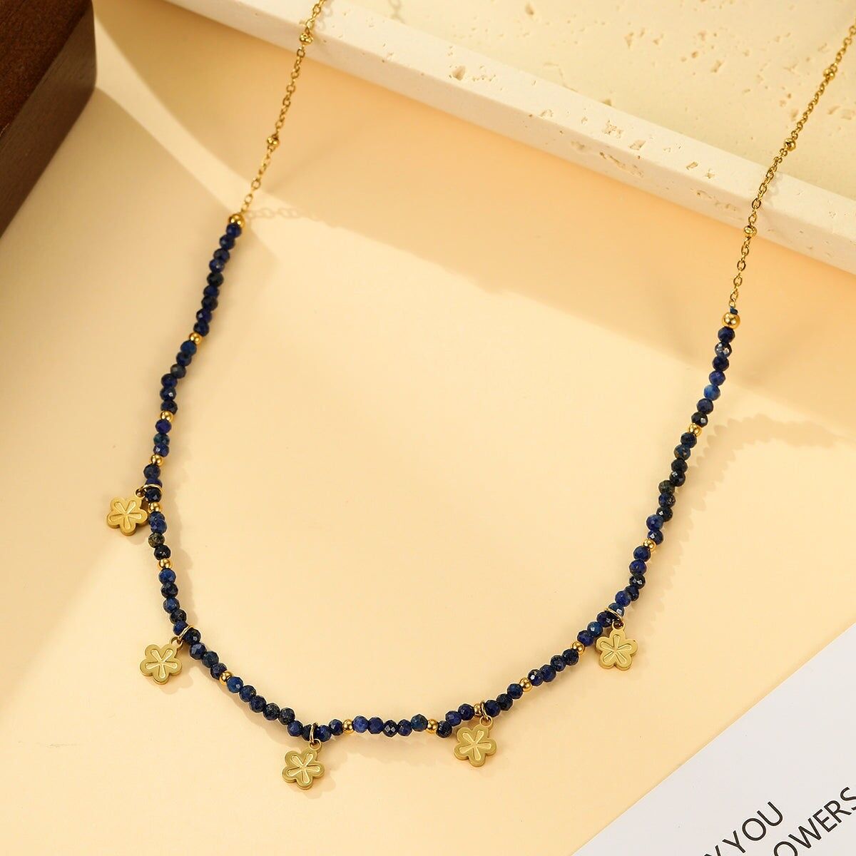 Collana in oro con perle sfaccettate di lapislazzuli blu e pendenti a forma di fiore