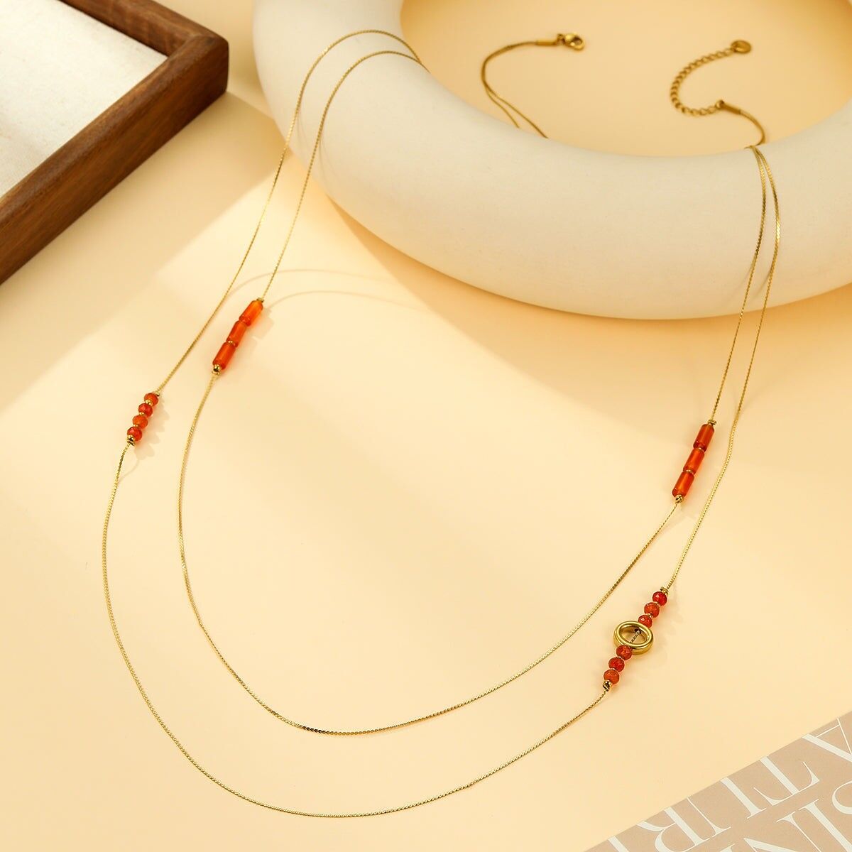 Collana a doppia catena con fili sottili e perline rosse e anello centrale