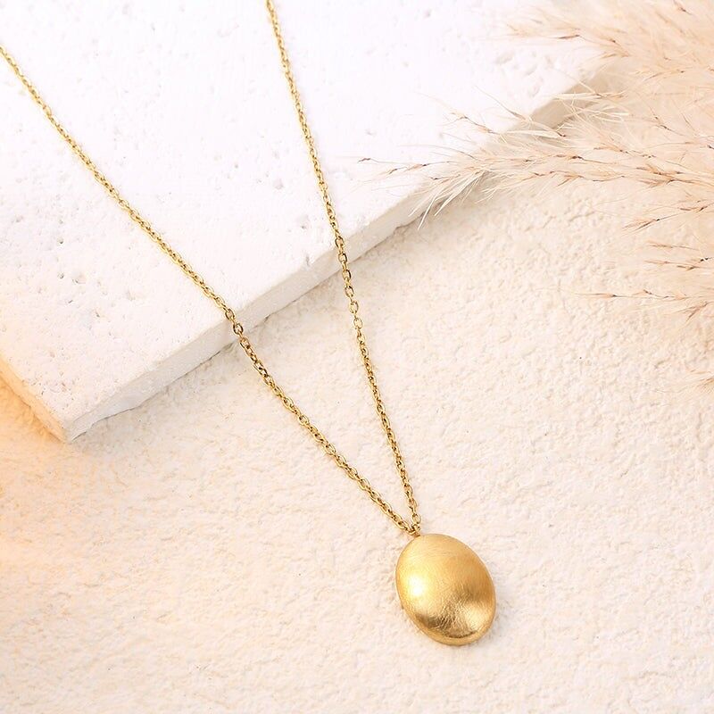 Collana con catena in oro e pendente ovale bombato con finitura spazzolata