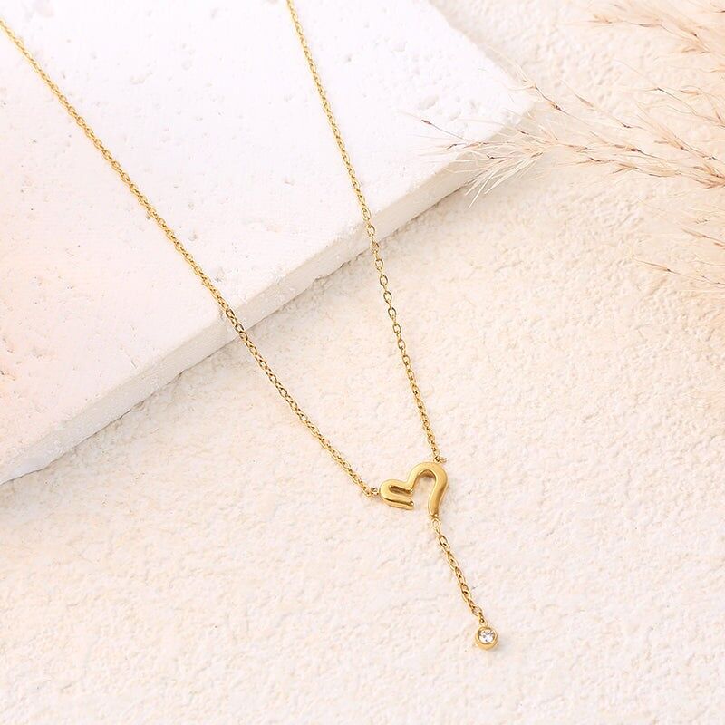 Collana con catena in oro con ciondolo a forma di cuore traforato e strass pendenti