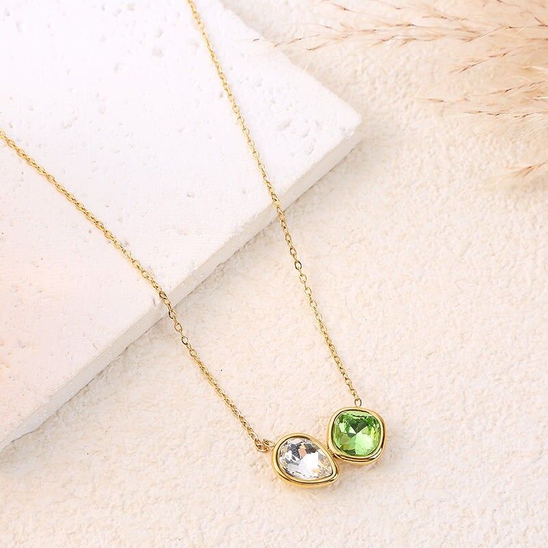 Collana con catena in oro con cristallo verde a forma di diamante arrotondato e goccia bianca