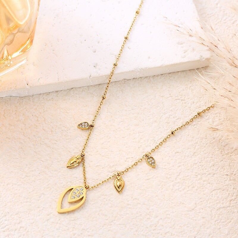 Collana con catena in oro decorata con trafori e gocce di strass