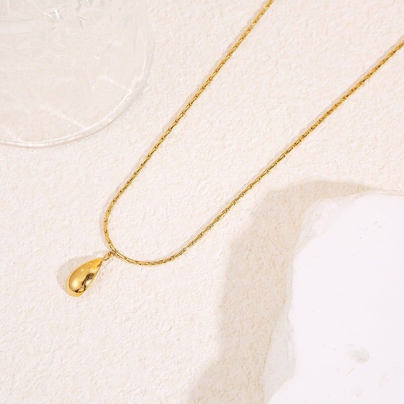 Collana con catena a serpente in oro pregiato e pendente a goccia allungato effetto specchio