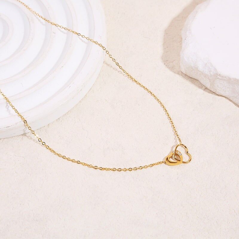 Collana con catena in oro fine con 2 pendenti a forma di cuore traforati sottili e spessi con strass