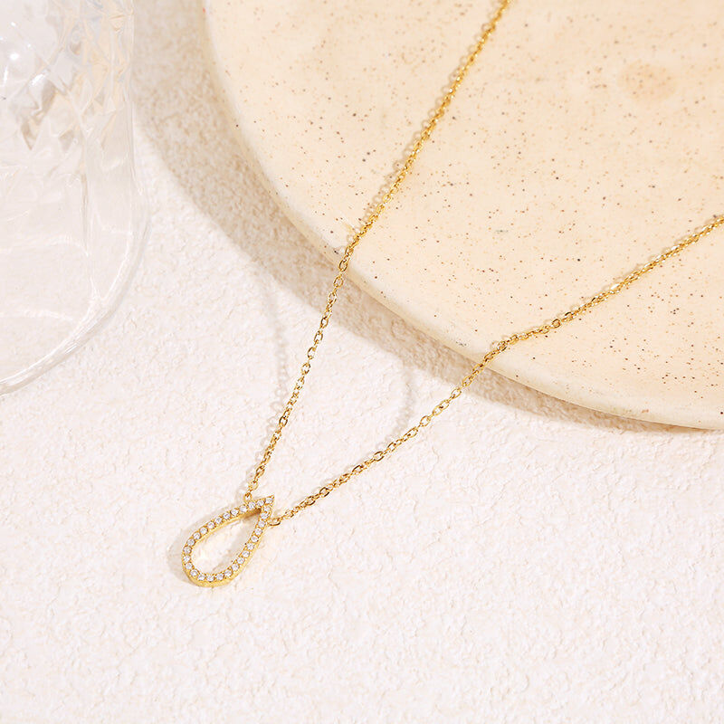 Delicate chain necklace with a central elongated teardrop shape adorned with rhinestones and rounded corners.