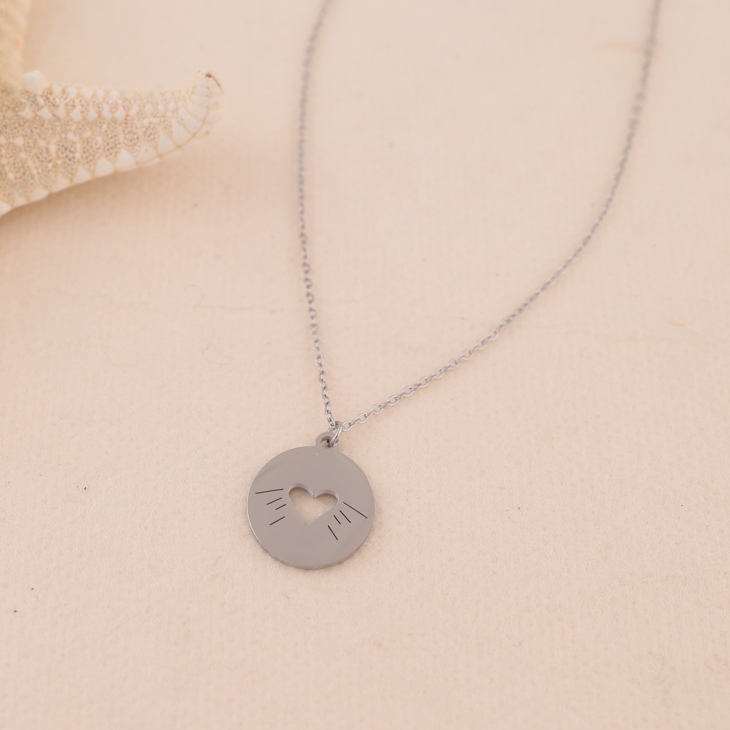 Collana in argento con catena sottile e ciondolo a forma di cuore rotondo traforato e incisioni