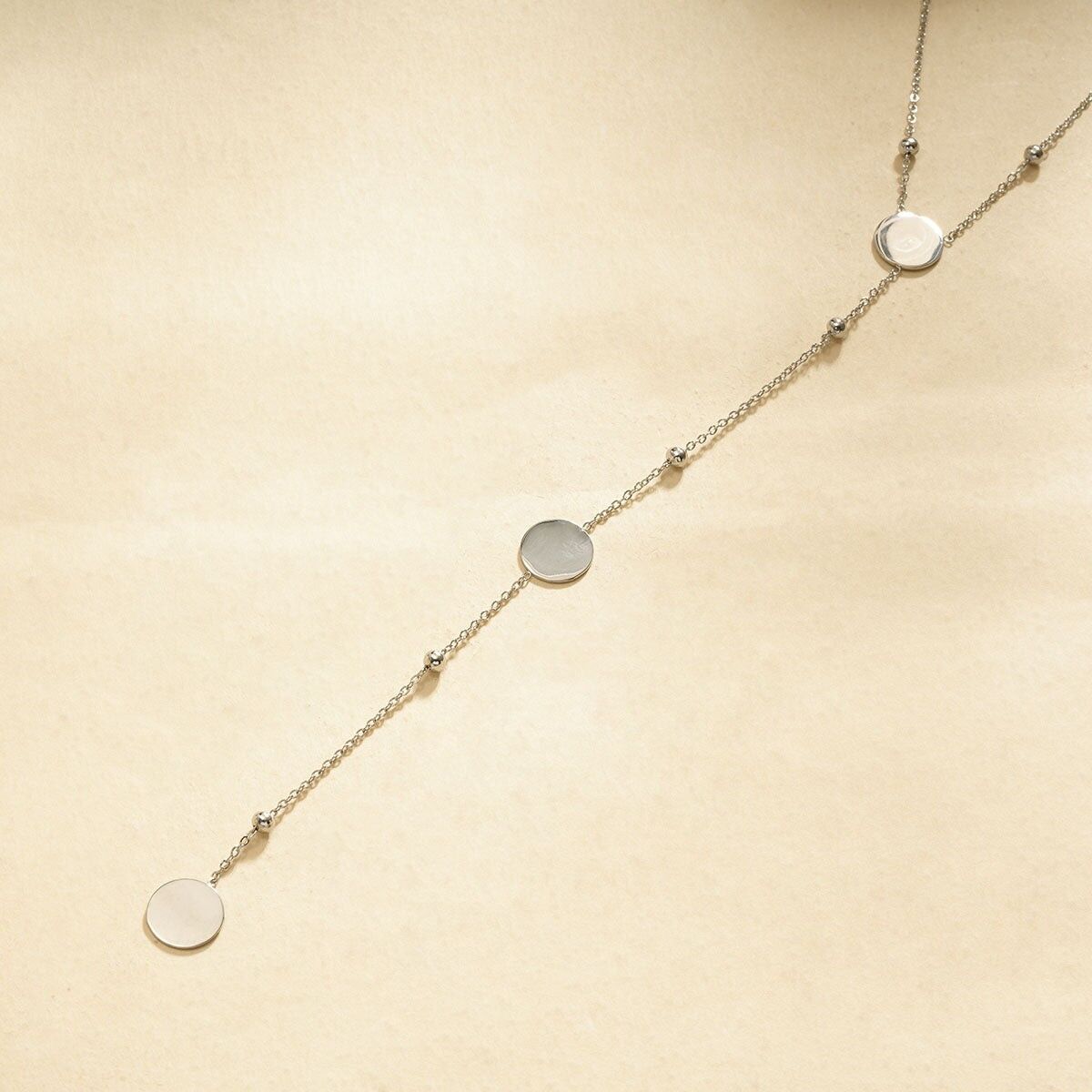 Collana in argento con pendenti rotondi lisci e perline metalliche distanziate su una catena sottile