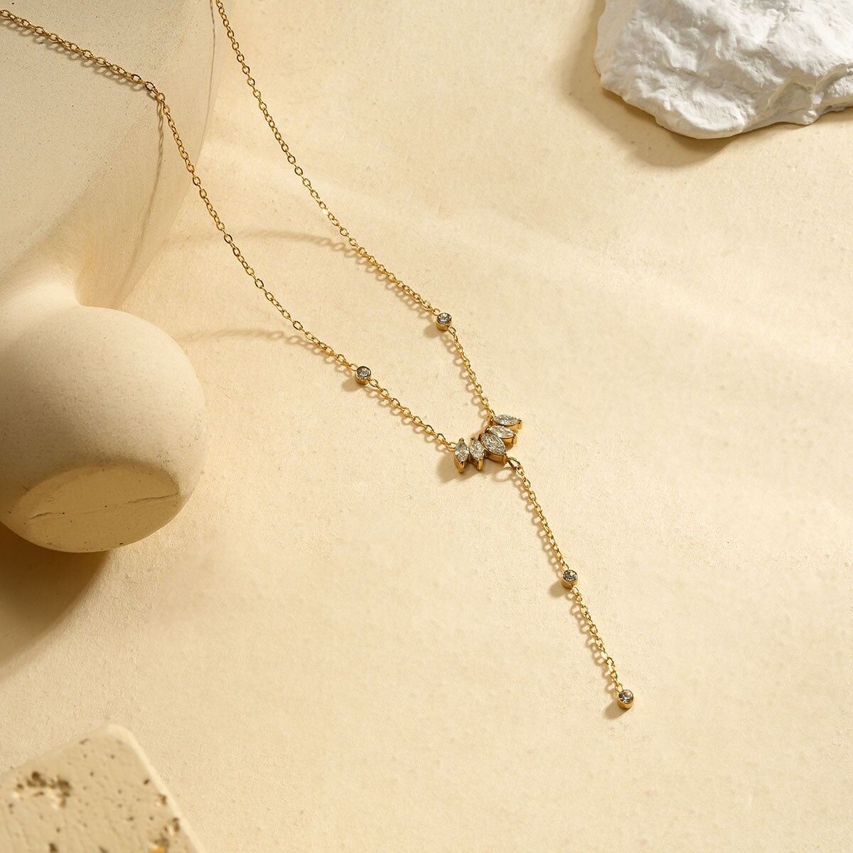 Collana in oro pregiato con pendente centrale a forma di freccia incastonato con strass e catena pendente ornata di cristalli