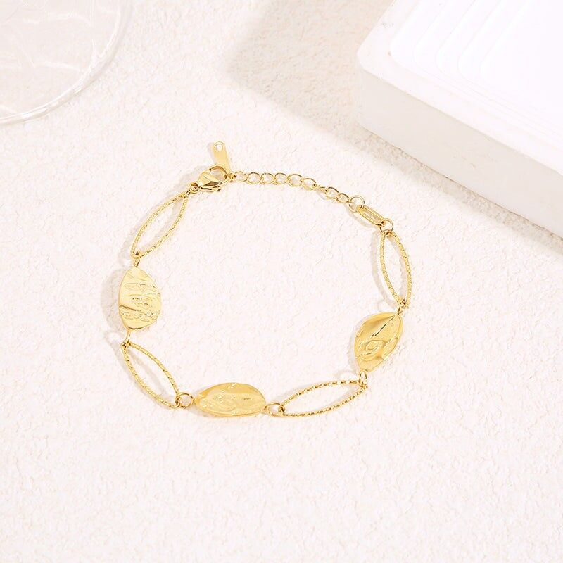 Goldarmband mit abwechselnd strukturierten ovalen Gliedern und Medaillons mit eingraviertem Blattmotiv